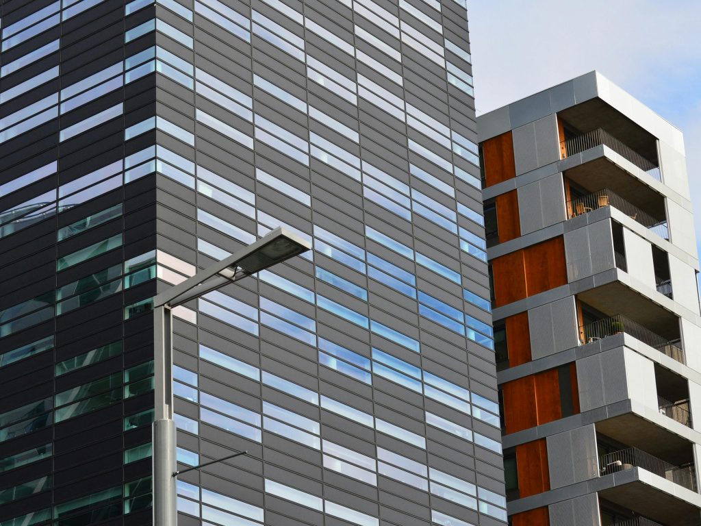 pexels-photo-273244-273244 Low angle view of a modern glass office building and residential structure in daylight.